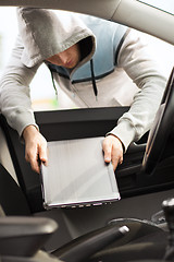 Image showing thief stealing laptop from the car