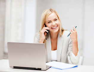 Image showing businesswoman with smartphone in office