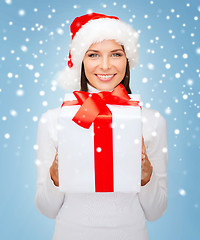 Image showing smiling woman in santa helper hat with gift box