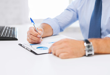 Image showing businessman working and signing papers