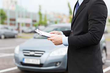 Image showing man with car documents outside