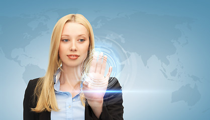 Image showing businesswoman touching virtual screen