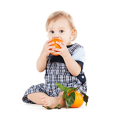Image showing cute toddler eating orange