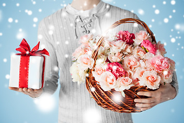 Image showing man holding basket full of flowers and gift box