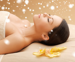 Image showing woman in spa salon lying on the massage desk