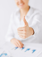 Image showing woman with charts, papers and thumbs up