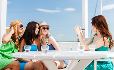 Image showing girls taking photo in cafe on the beach