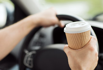 Image showing man drinking coffee while driving the car