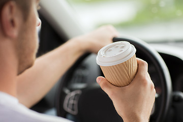 Image showing man drinking coffee while driving the car