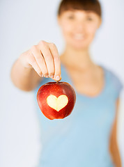 Image showing woman hand holding red apple with heart shape