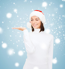 Image showing woman in santa helper hat with something on palm