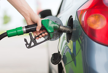 Image showing man pumping gasoline fuel in car at gas station