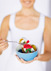 Image showing woman hands holding bowl with measuring tape