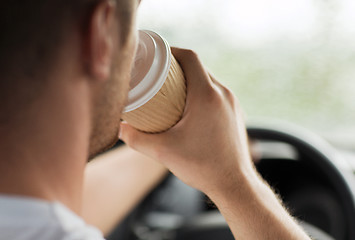 Image showing man drinking coffee while driving the car