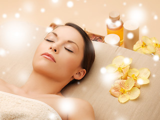 Image showing woman in spa salon lying on the massage desk