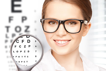 Image showing woman with magnifier and eye chart