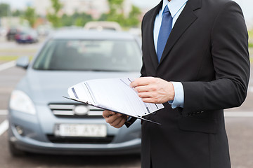 Image showing man with car documents outside