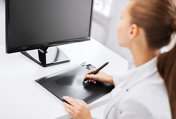 Image showing businesswoman with drawing tablet in office