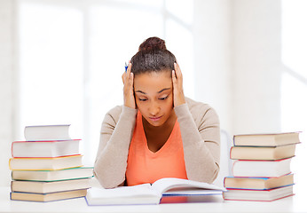 Image showing tired student with books and notes