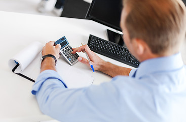 Image showing businessman with notebook and calculator