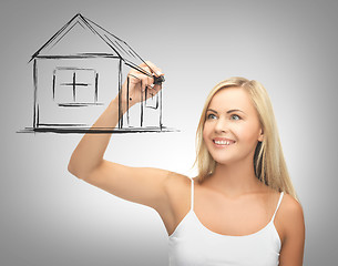 Image showing woman drawing house on virtual screen