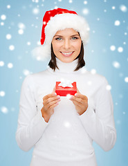 Image showing smiling woman in santa hat with small gift box