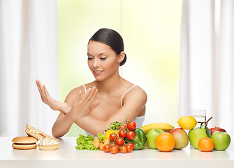 Image showing woman with fruits rejecting junk food