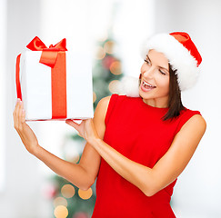 Image showing smiling woman in santa helper hat with gift box