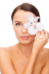 Image showing relaxed woman with or??hid flower over eye