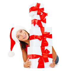 Image showing smiling woman in santa helper hat with gift boxes