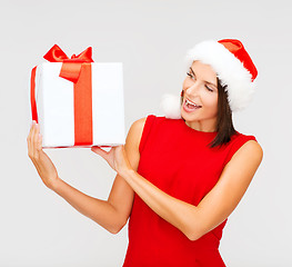 Image showing smiling woman in santa helper hat with gift box