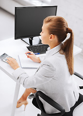 Image showing businesswoman with notebook and calculator