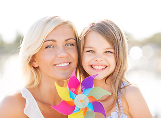 Image showing happy mother and child girl with pinwheel toy