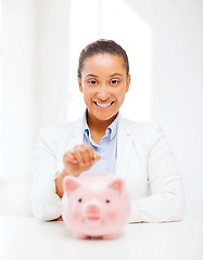 Image showing woman with piggy bank and coin