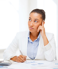 Image showing businesswoman working with calculator in office