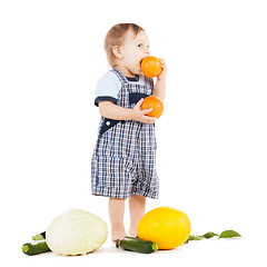 Image showing toddler with vegetables eating orange