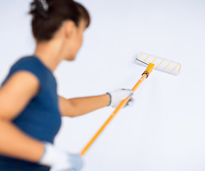 Image showing woman with roller and paint colouring the wall