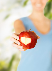 Image showing woman hand holding red apple with heart shape