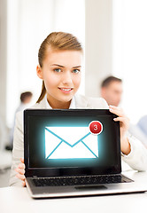 Image showing businesswoman holding laptop with email sign