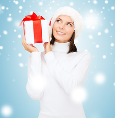 Image showing smiling woman in santa helper hat with gift box