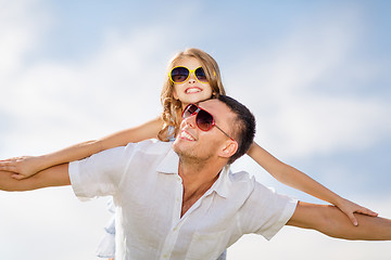 Image showing happy father and child in sunglasses over blue sky