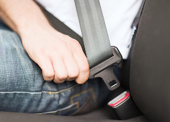 Image showing man fastening seat belt in car