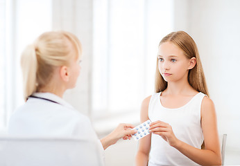 Image showing doctor giving tablets to child in hospital