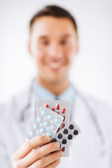 Image showing male doctor with packs of pills