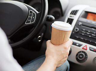 Image showing man drinking coffee while driving the car