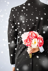 Image showing man hiding bouquet of flowers