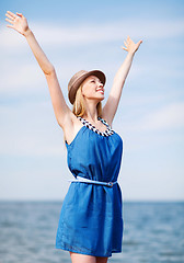 Image showing girl with hands up on the beach