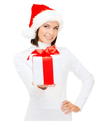 Image showing smiling woman in santa helper hat with gift box