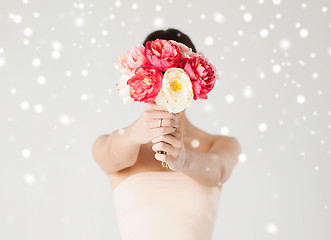 Image showing woman holding bouquet of flowers over her face