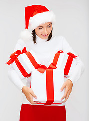 Image showing woman in santa helper hat with many gift boxes